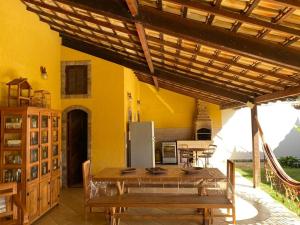 布希奥斯Casa Três Amores的厨房设有黄色的墙壁、桌子和冰箱