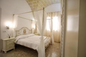 法维尼亚纳AFFITTACAMERE I PACIORRA的白色卧室设有天蓬床和窗户