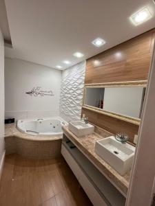 卡舒埃拉保利斯塔Estadia na Canção Nova的浴室配有两个盥洗盆和浴缸。