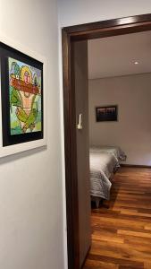 亚松森Madre Natura的一间设有一张床的客房,墙上挂着一幅画