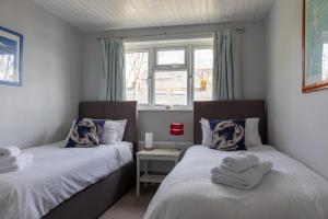 索尔科姆2 Church Hill House的一间卧室设有两张床和窗户。