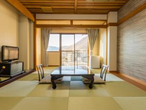 笛吹市Japanese Onsen Ryokan Kohakuen的一间带桌子和大窗户的用餐室