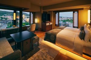 京都Sora Niwa Terrace Kyoto Bettei的酒店客房设有一张床、一张书桌和窗户。