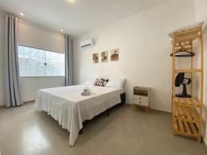 阿拉亚尔达茹达Casa do Villas - Arraial d'Ajuda的一间卧室配有一张带白色床单和梯子的床。