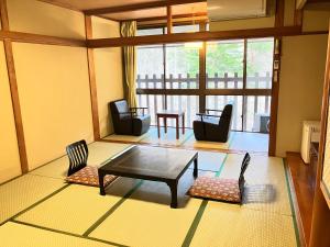 日光汤西川日式旅馆的客厅配有咖啡桌和椅子