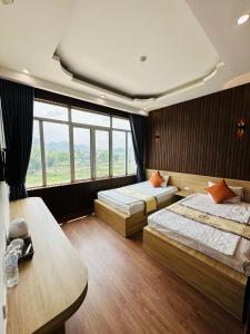 高平Minh Hoang Hotel & Homestay的一间卧室设有两张床和大窗户