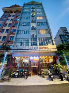 高平Minh Hoang Hotel & Homestay的一座大建筑前面设有桌椅