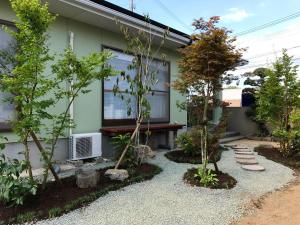 MifuneYuuwa Guesthouse的一座花园,在房子前面有树木