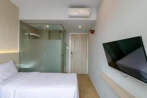 棉兰Swasana Hotel near Plaza Medan Fair Mitra RedDoorz的一间卧室配有一张床和一台平面电视