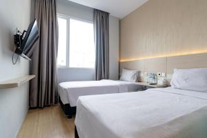 棉兰Swasana Hotel near Plaza Medan Fair Mitra RedDoorz的酒店客房设有两张床和窗户。