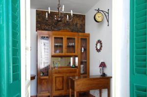 利多迪卡马约雷Old Time Lido的墙上有桌子和时钟的房间