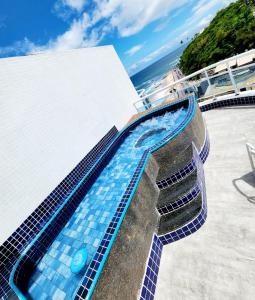 萨尔瓦多Cobertura em Ondina的一座建筑物边的蓝色瓷砖游泳池