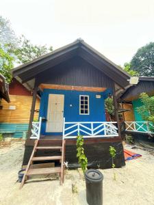 停泊岛Bee Chalet Perhentian Island的蓝色的房子,前面有楼梯