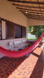 萨夸雷马Casa de Temporada - Solar Guest House的房屋内的吊床,配有两把椅子和电视