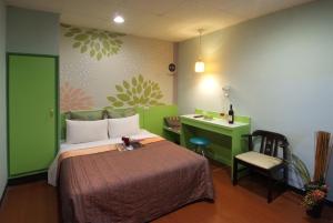 新竹東賓快捷旅店的一间卧室配有一张床、一张书桌和一张书桌