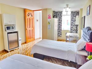 利马Hospedaje Celerina & Elio的酒店客房带两张床和厨房