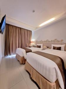 库塔Horison Kuta Bali的酒店客房设有四张床和平面电视。