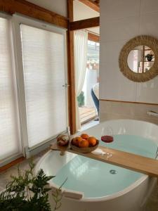 庆州EL House的浴缸里放着一碗橘子和一杯葡萄酒
