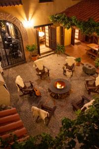 卡法亚特比库尼亚葡萄酒别墅精品酒店的庭院设有火坑、椅子和吉他