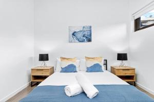 悉尼Centre of Newtown 2 Bed Apartment的一间卧室配有白色床和2个床头柜