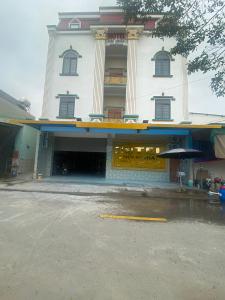 Hoi NghiaKhách Sạn Hội Nghĩa Bình Dương的一座白色的大建筑,设有窗户和雨伞