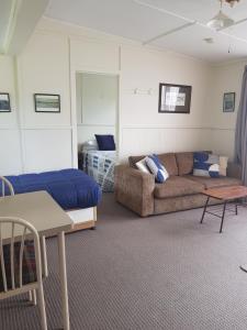 WaitahanuiWaitahanui Lodge的客厅配有沙发和1张床