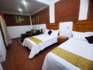 TasquilloHotel Boutique Casona Mashei的酒店客房,设有两张床和一张沙发