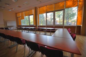 德鲁斯基宁凯代纳瓦酒店的大型会议室,配有大桌子和椅子
