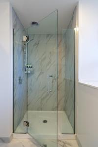 基督城Indulge in Christchurch Hagley Park 2 bed 2 bath的浴室里设有玻璃门淋浴