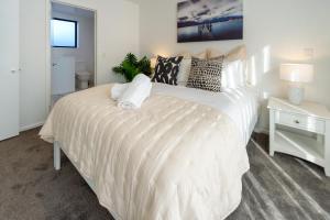 基督城Indulge in Christchurch Hagley Park 2 bed 2 bath的卧室配有带枕头的大型白色床