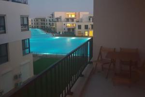 亚历山大Lovely 3-bedroom vacation home -Marassi的从公寓的阳台可欣赏到游泳池的景色