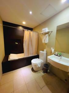 马尼拉88万怡酒店 的浴室配有卫生间、盥洗盆和浴缸。