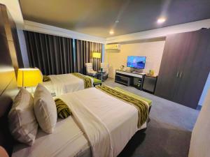 马尼拉88万怡酒店 的酒店客房设有两张床和电视。