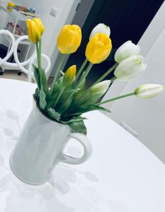萨莱诺Tutta un'altra vista的白色的花瓶,花朵黄色,白色