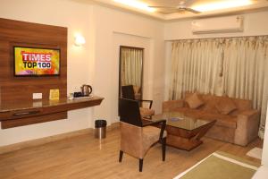 印多尔Kyriad Hotel Indore by OTHPL的客厅配有沙发和桌子