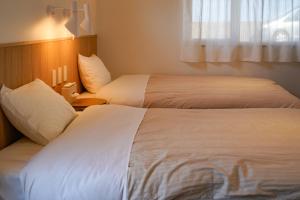 SanukiBeach SPA TSUDA 1 Uno的酒店客房设有两张床和窗户。