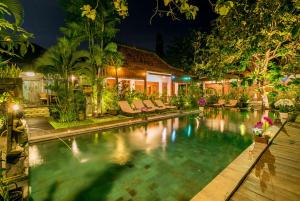 沙努尔甘榜科希尔别墅的夜间在房子前面的游泳池