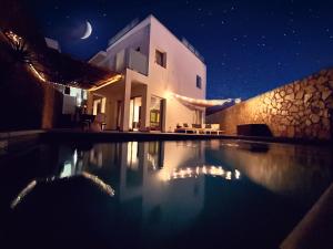 莫甘Escape to paradise luxury Poolvilla with ocieanview near Amadores的一座晚上设有游泳池的房子