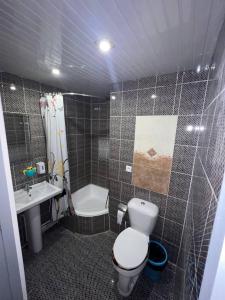 布哈拉Hotel Guest House GOLDEN DEGREZ的浴室配有卫生间、盥洗盆和淋浴。