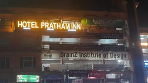 艾哈迈达巴德Hotel Pratham Inn的建筑上标有酒店帕特金旅馆标志