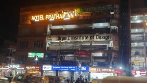 艾哈迈达巴德Hotel Pratham Inn的一座建筑物,晚上有标志