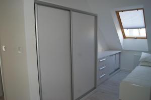 波莫瑞地区卡缅Kama Apartament Kamień Pomorski的卧室内的滑动玻璃门,配有床