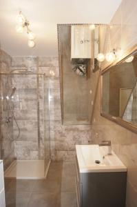 波莫瑞地区卡缅Kama Apartament Kamień Pomorski的带淋浴、盥洗盆和镜子的浴室