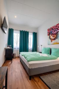 汉诺威Löwen Unterkunft Langenhagen的一间卧室配有一张带绿色床单和蓝色窗帘的床
