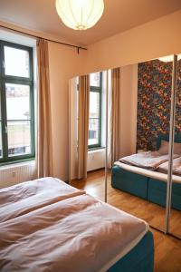 莱比锡Cityloft - im Zentrum, inkl Parkplatz, Netflix, 3-Raum的一间卧室设有两张床和两个窗户。