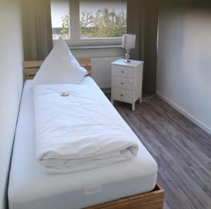 兰河畔马尔堡Ferienwohnung in Marburg/Wehrda的一间卧室配有一张带白色床单的床和一扇窗户。