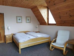 高塔特拉山Privát Kováč的一间卧室配有一张床和一把椅子