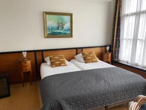 哈林亨咖瑞基恩民宿旅馆的卧室配有一张床,墙上挂着一幅画