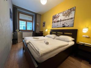 布拉格中央一室公寓的一间卧室设有一张大床和黄色的墙壁