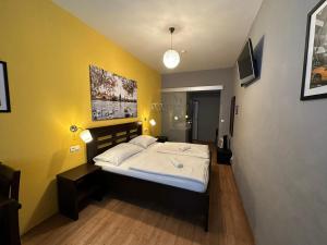布拉格中央一室公寓的一间卧室设有一张床和黄色的墙壁